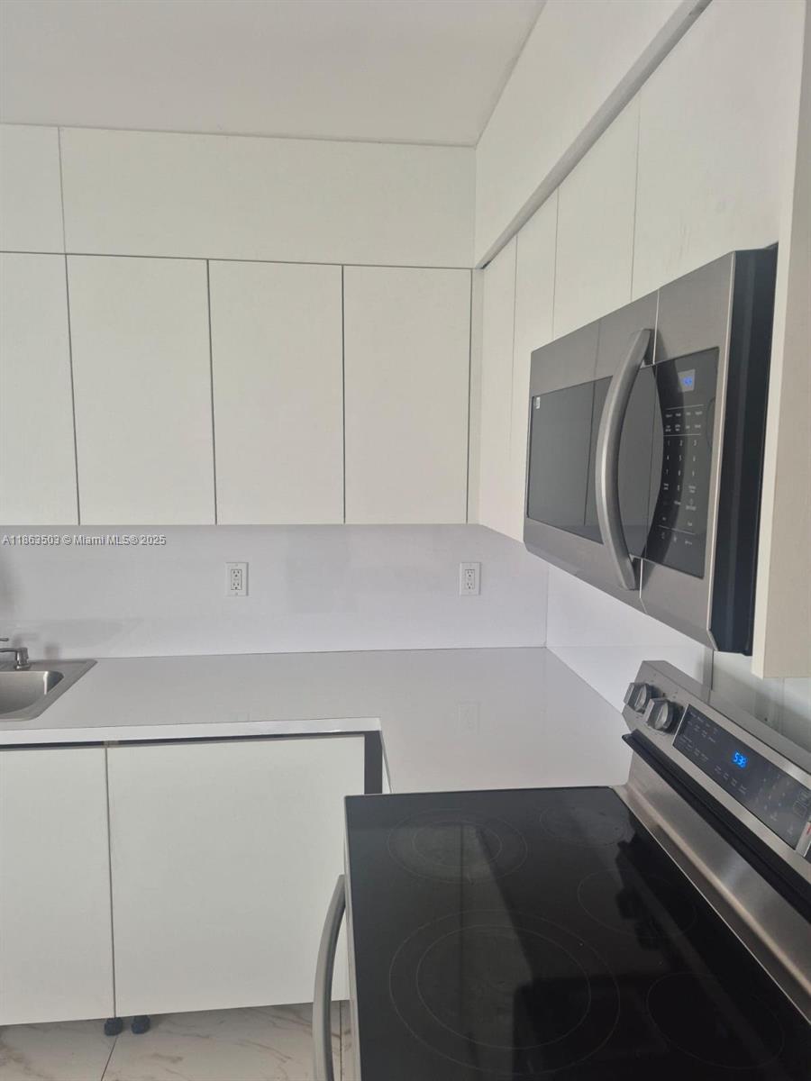 7756 Washington Avenue, Unit 7758 Lake Worth, FL 33462 - Photo 7 of 15 a bathroom with a sink and a washer dryer