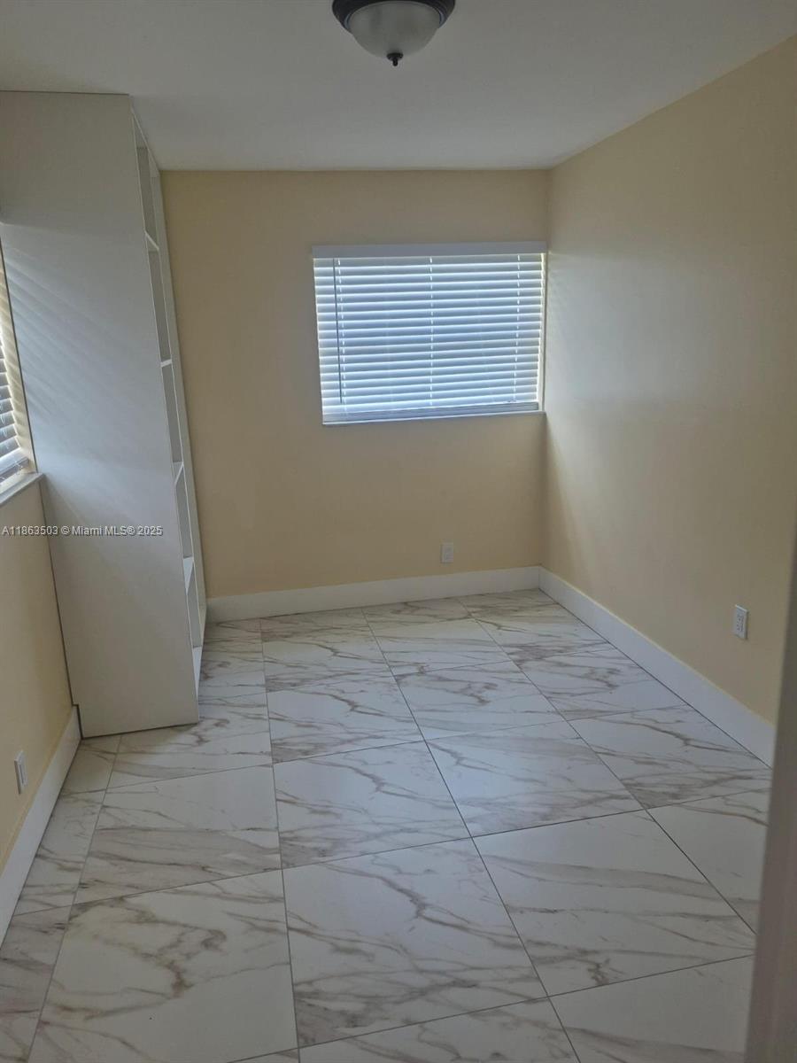 7756 Washington Avenue, Unit 7758 Lake Worth, FL 33462 - Photo 10 of 15 an empty room with a empty space and windows