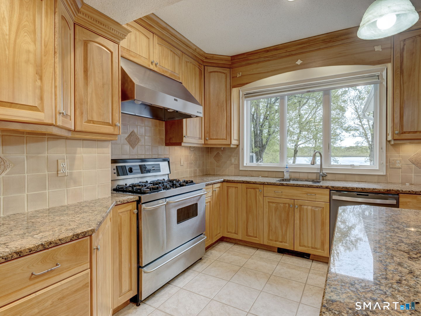 501 Highland Street Wethersfield, CT 06109 - Photo 9 of 38 a kitchen with granite countertop a sink stainless steel appliances and cabinets