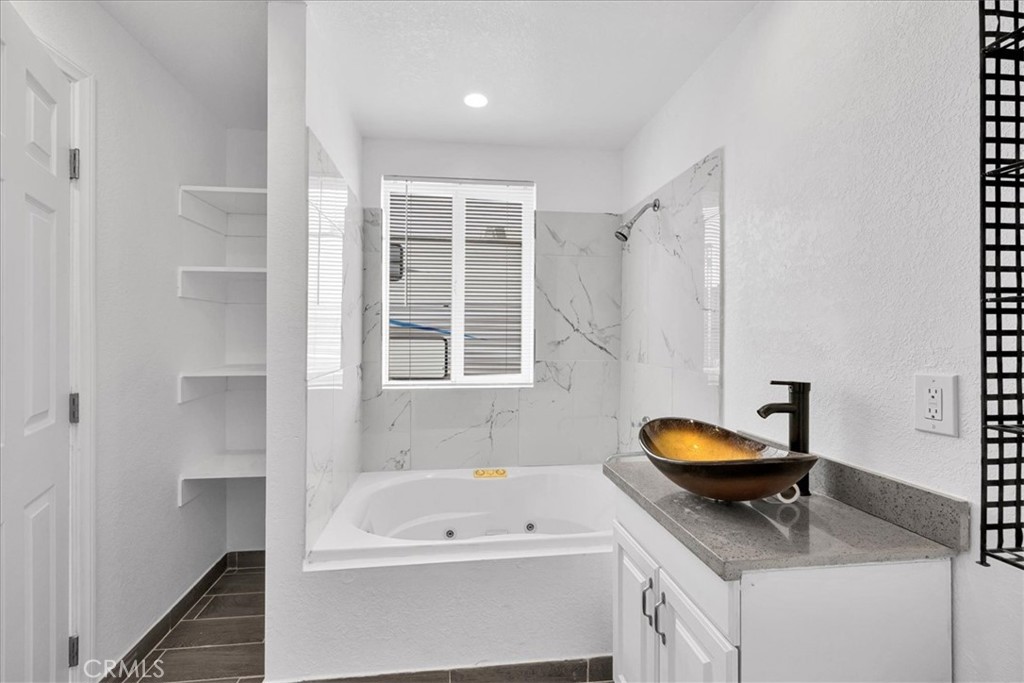 57726 Starlight Mesa Road Yucca Valley, CA 92284 - Photo 14 of 75 a bathroom with a tub a sink and a window