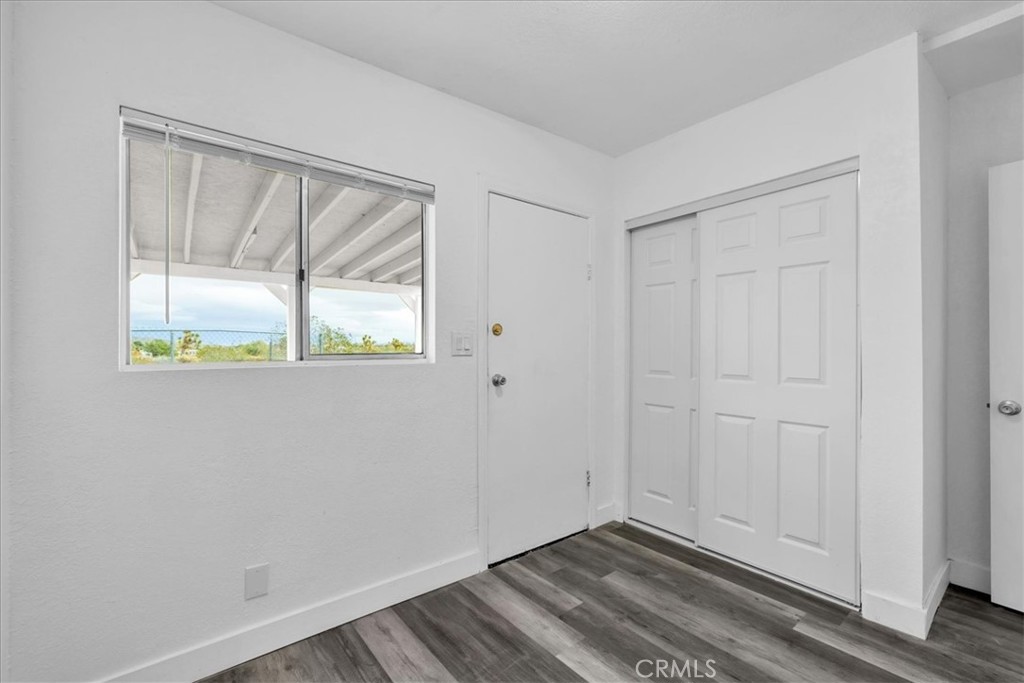 57726 Starlight Mesa Road Yucca Valley, CA 92284 - Photo 22 of 75 a view of an empty room with wooden floor and a window