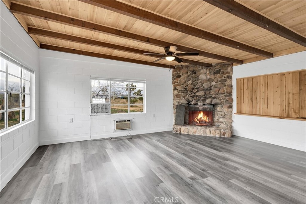57726 Starlight Mesa Road Yucca Valley, CA 92284 - Photo 3 of 75 an empty room with wooden floor fireplace and windows