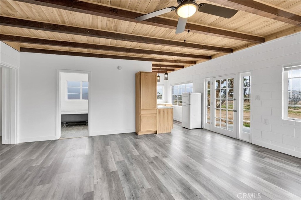 57726 Starlight Mesa Road Yucca Valley, CA 92284 - Photo 5 of 75 a view of an empty room with wooden floor and a window