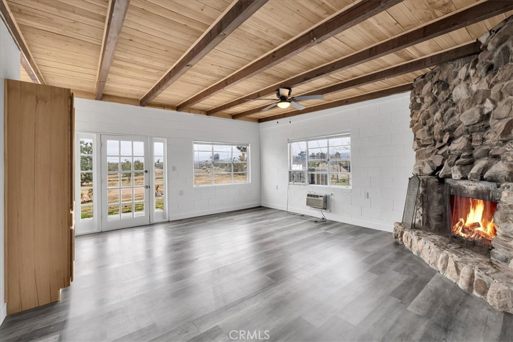 57726 Starlight Mesa Road Yucca Valley, CA 92284 - Photo 6 of 75 a view of an empty room with a window and wooden floor