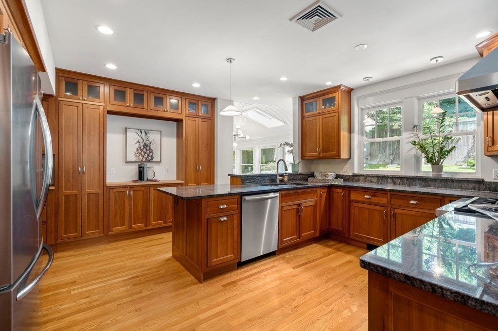 25 Windsor Road Brookline, MA 02445 - Photo 7 of 31 a large kitchen with stainless steel appliances granite countertop a refrigerator a sink dishwasher and wooden cabinets with wooden floor