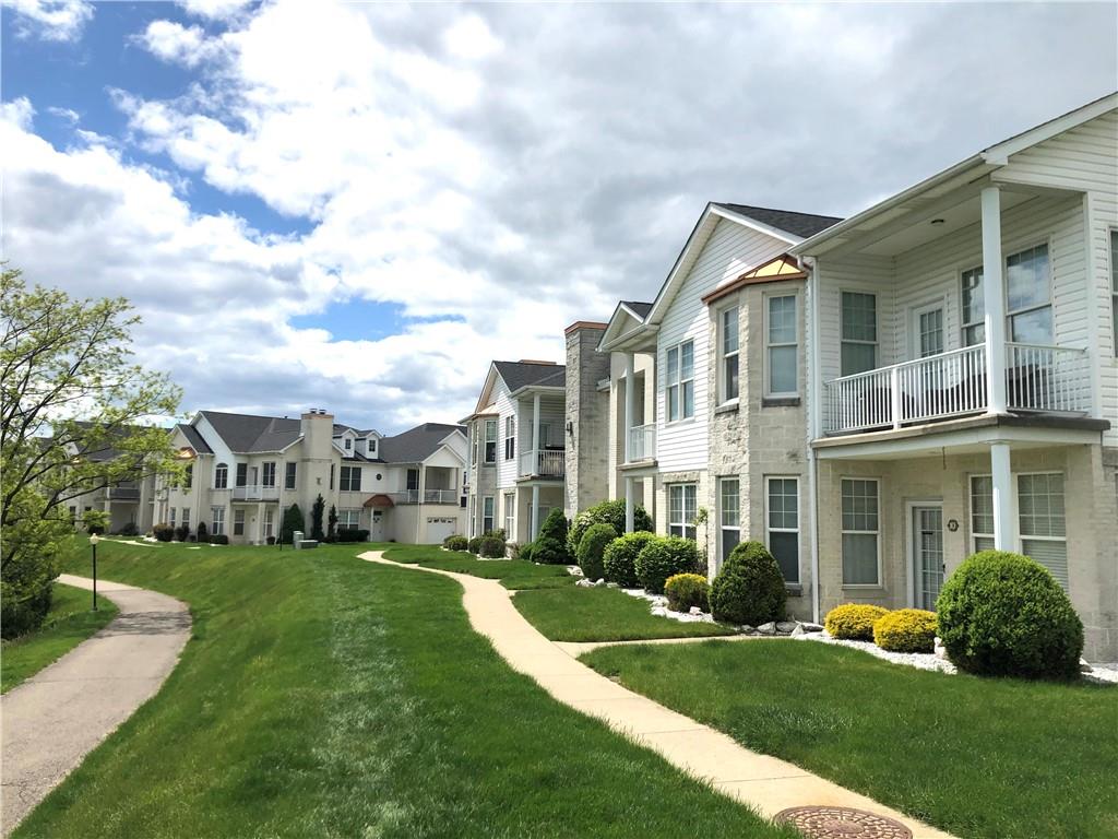 211 Adams Pointe Boulevard, Unit 10 Mars, PA 16046 - Photo 24 of 33 a view of a white house next to a yard with big trees