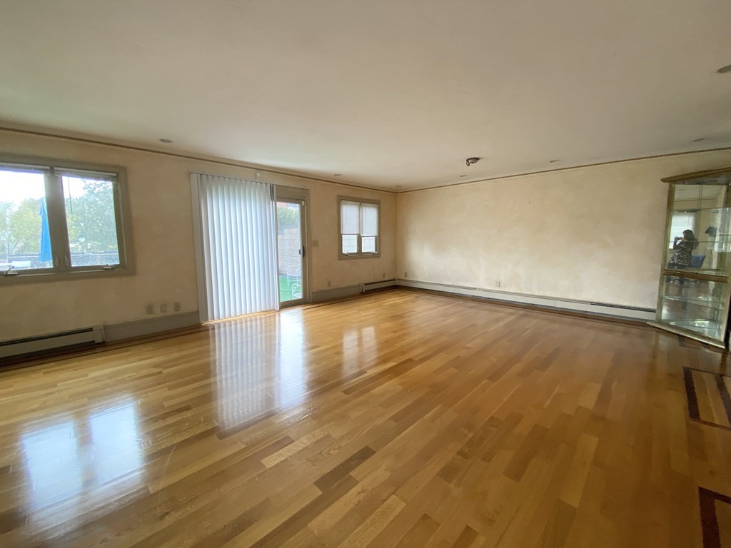 99 St Marys Street, Unit 99 Brookline, MA 02446 - Photo 2 of 14 an empty room with wooden floor and windows