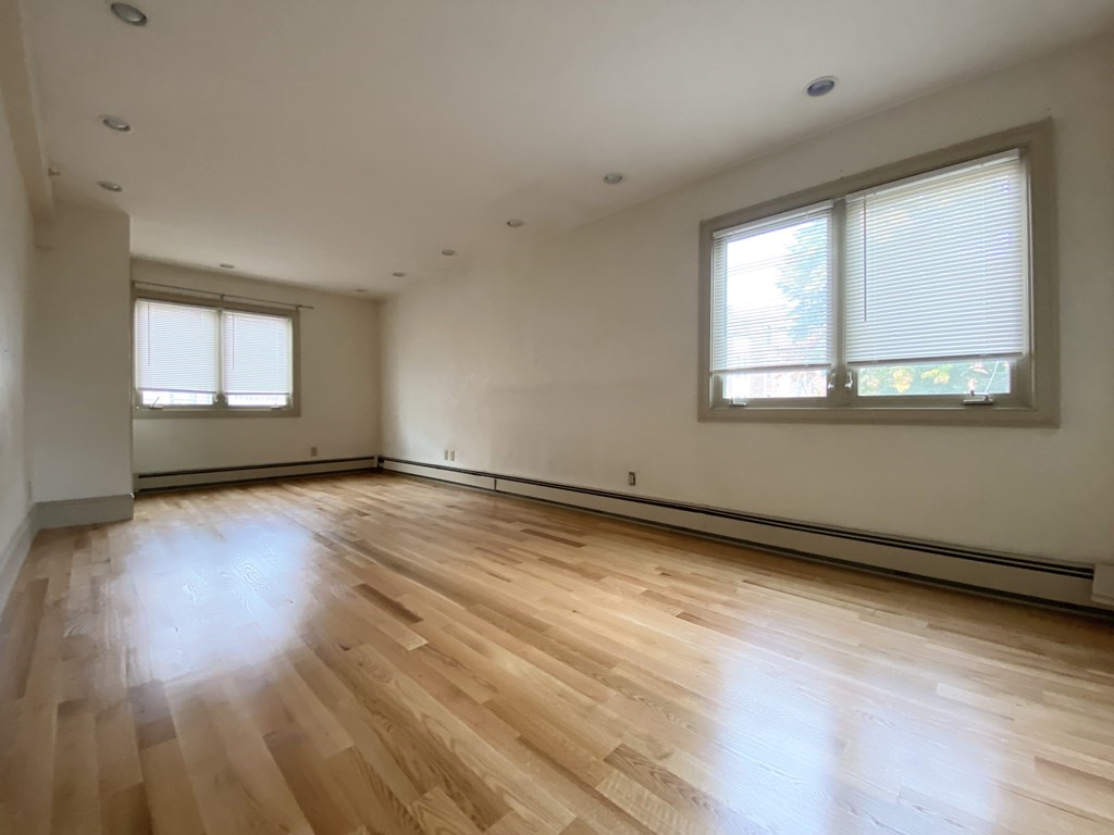 99 St Marys Street, Unit 99 Brookline, MA 02446 - Photo 6 of 14 a view of an empty room with wooden floor and a window