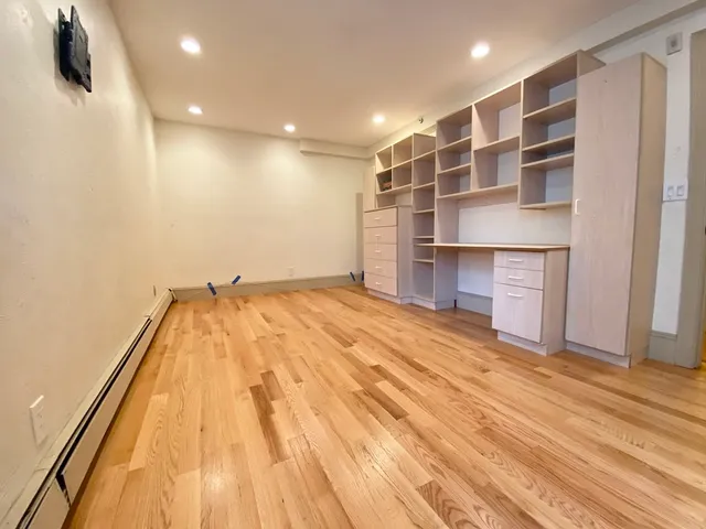 a view of a room with wooden floor and a ceiling fan
