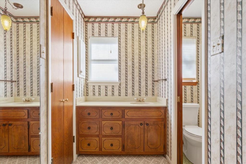 208 South Hedwig Street Riesel, TX 76682 - Photo 21 of 31 Full bath with two vanities, plenty of natural light, and wallpapered walls