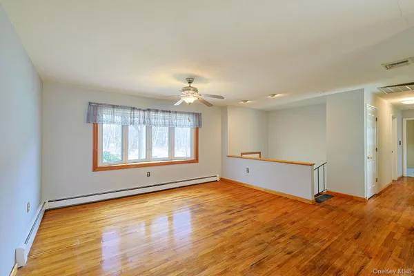 a big room with windows and chandelier fan