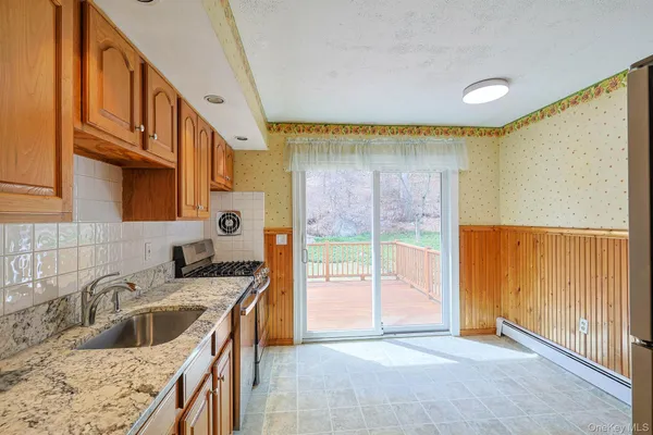 a kitchen with stainless steel appliances granite countertop a sink a stove and a refrigerator
