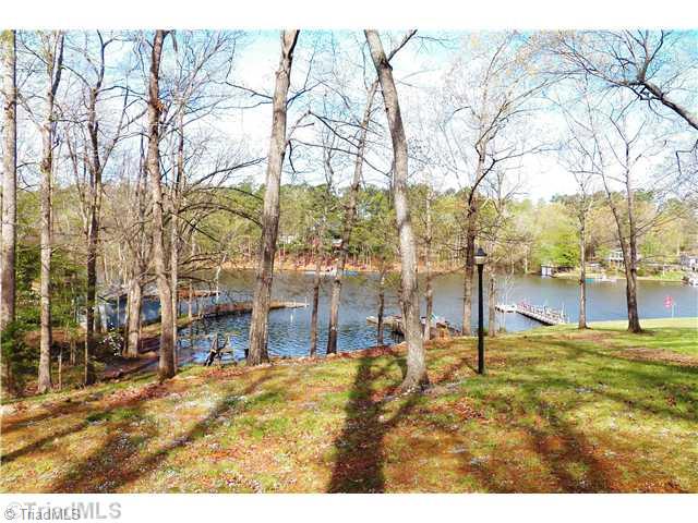 560 Lake Ridge Trail Denton, NC 27239 - Photo 3 of 16 View. View of the lake from the wrap around deck. Spring has just arrived and the grass and leaves are just greening up. Natural setting, lots of mature shade trees and afternoon sun and sunsets
