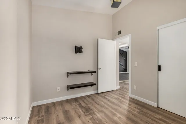 a view of empty room with wooden floor