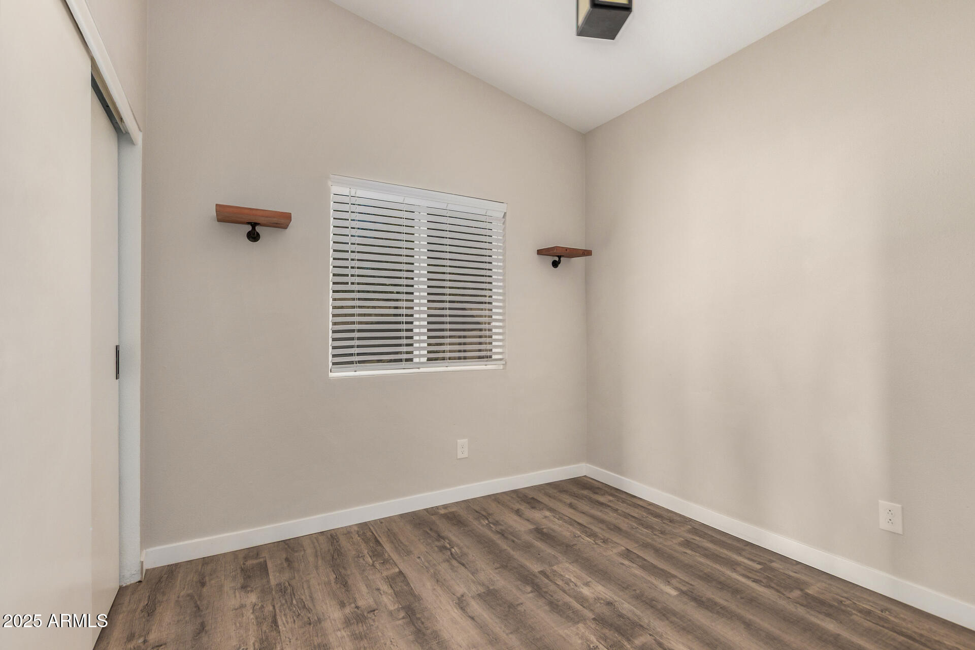 421 East Wickieup Lane Phoenix, AZ 85024 - Photo 13 of 24 a view of an empty room with wooden floor and a window