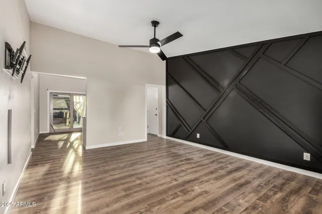 a view of a livingroom with wooden floor and a ceiling fan