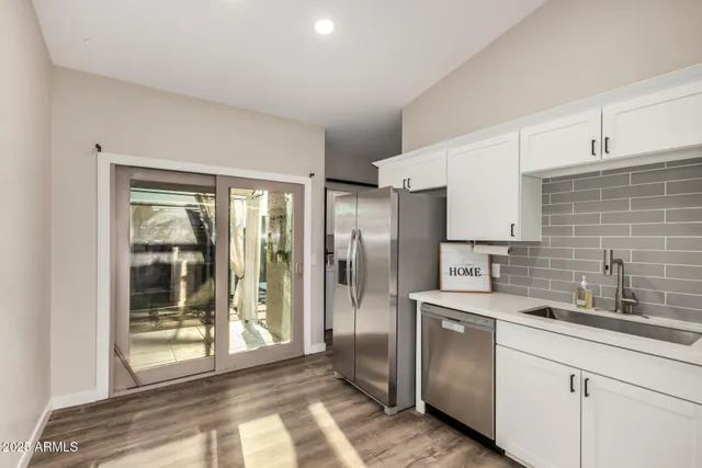 a kitchen with stainless steel appliances granite countertop a refrigerator and a sink