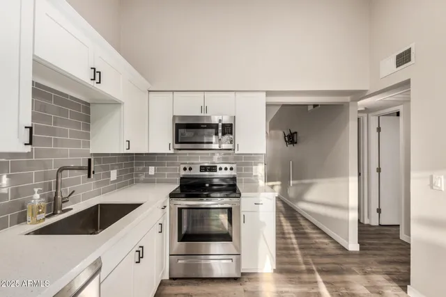 a kitchen with stainless steel appliances a stove a sink and a microwave