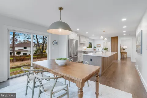 a view of a dining room and livingroom with furniture wooden floor a chandelier