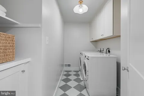 a utility room with cabinets washer and dryer