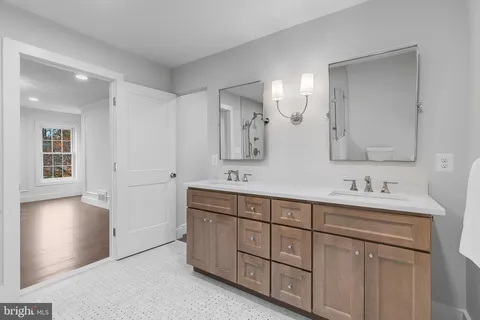 a spacious bathroom with a double vanity sink a mirror and a