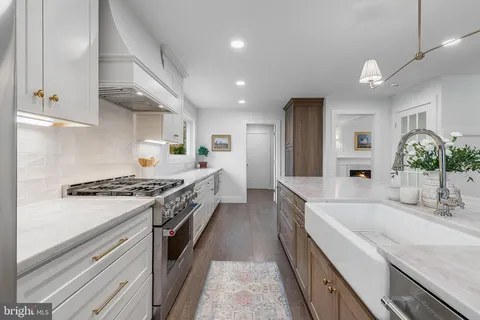 a large kitchen with stainless steel appliances granite countertop a lot of counter space and wooden floor
