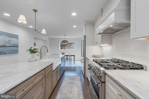 a kitchen with stainless steel appliances granite countertop a sink stove and cabinets