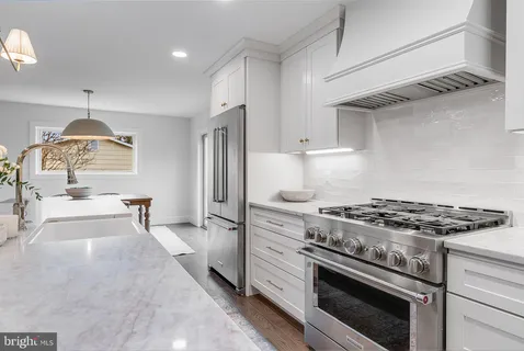 a kitchen with stainless steel appliances granite countertop a stove and a refrigerator