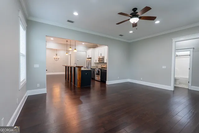 a kitchen with stainless steel appliances granite countertop a refrigerator a stove and a sink with wooden floor