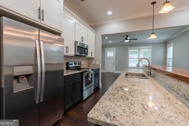 a kitchen with granite countertop a stove and a microwave