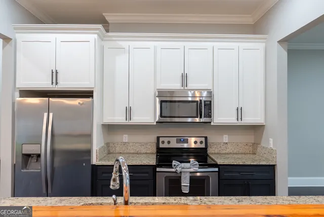 a kitchen with stainless steel appliances granite countertop stove top oven and refrigerator