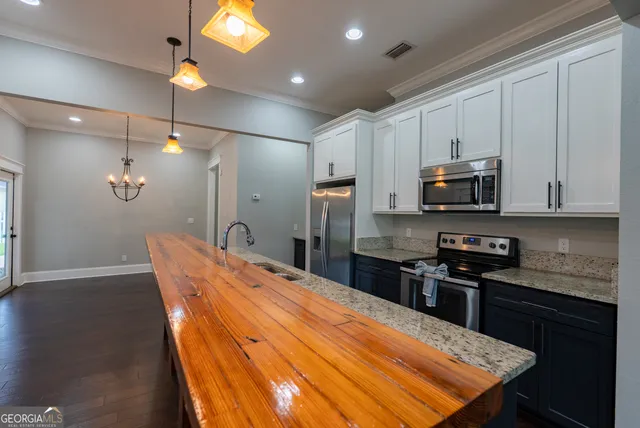 a kitchen with a sink a counter space and a chandelier
