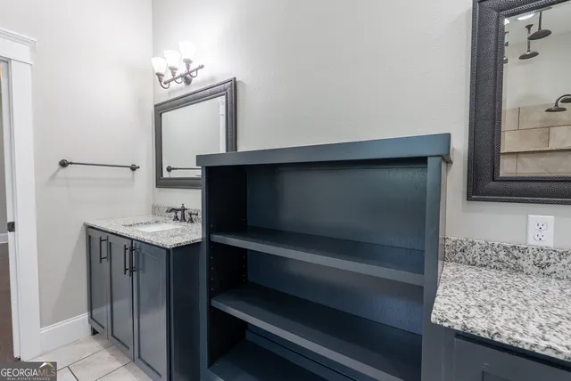a bathroom with a granite countertop sink and a mirror