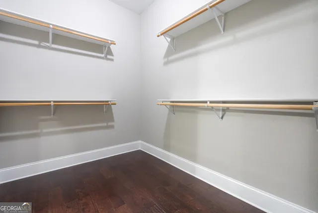 a view of walk in closet with wooden floor