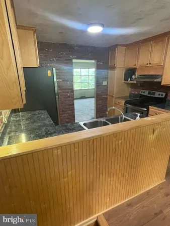 a kitchen with stainless steel appliances granite countertop wooden cabinets a granite counter top and a sink