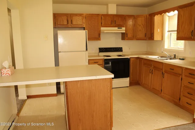 a kitchen with a sink a stove and a refrigerator