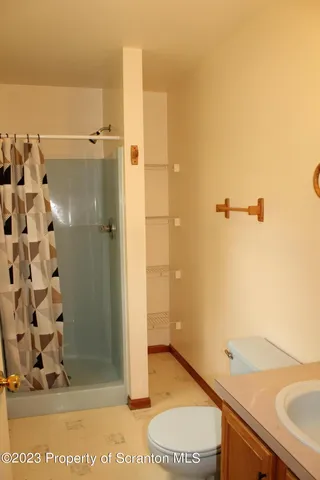 a bathroom with a granite countertop sink mirror vanity and toilet