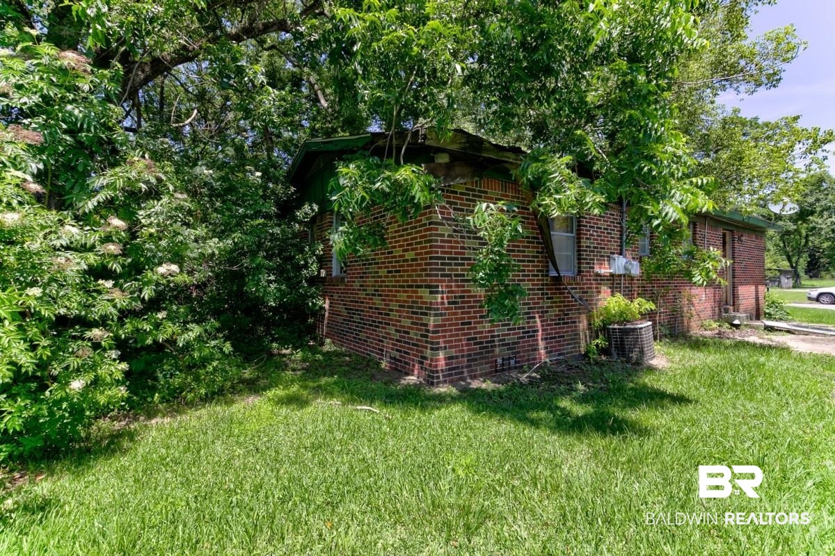 1603 Wexford Street Mobile, AL 36605 - Photo 5 of 10 View of side of home with brick siding and a lawn