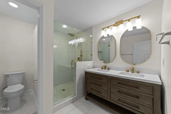 a bathroom with a double vanity sink mirror and toilet