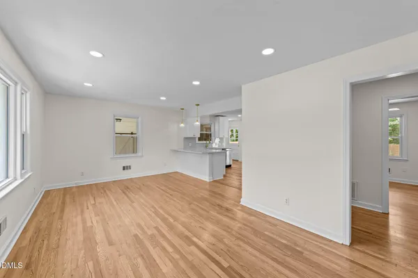 a view of a kitchen with wooden floor and a window