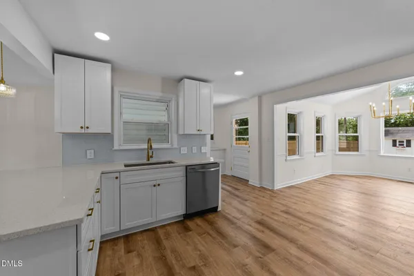 a kitchen with stainless steel appliances granite countertop a sink and cabinets with wooden floor