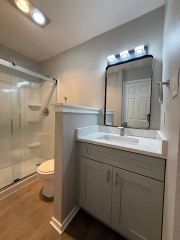 a bathroom with a sink a toilet and shower