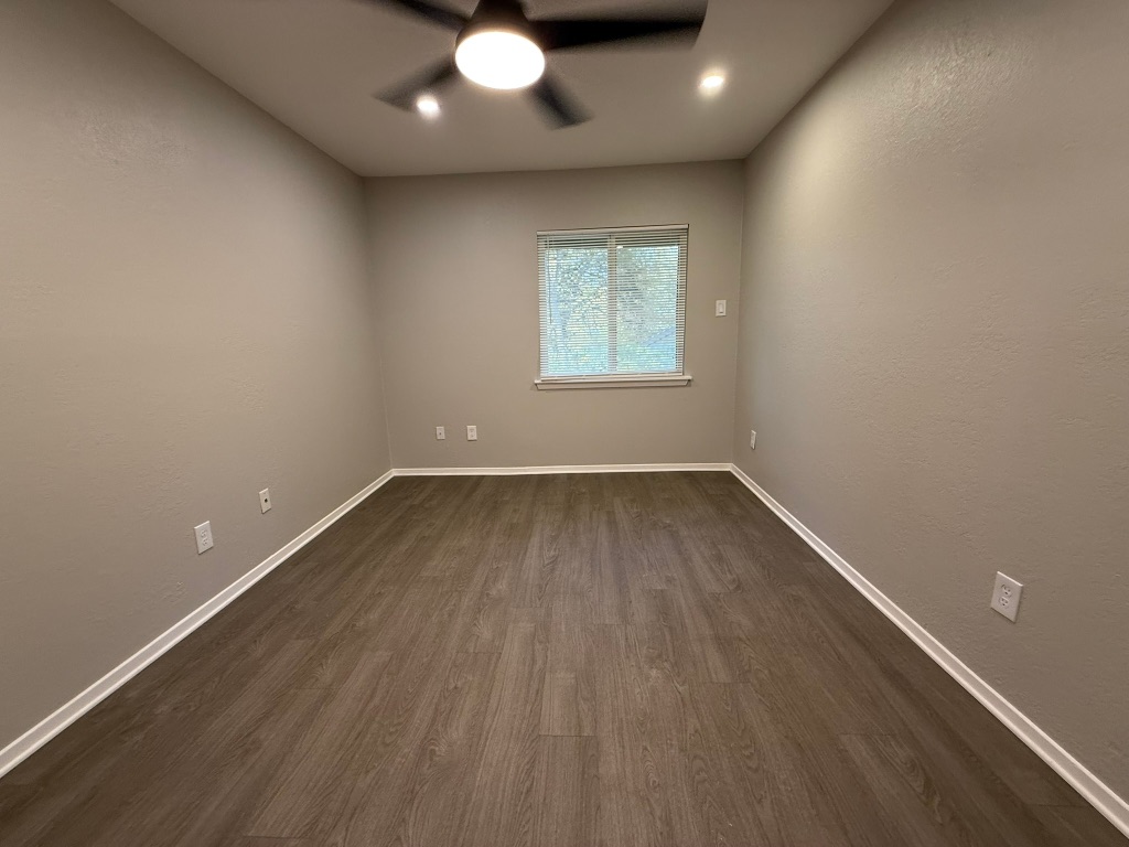 1606 Waterloo Trail, Unit A Austin, TX 78704 - Photo 14 of 17 an empty room with wooden floor and windows