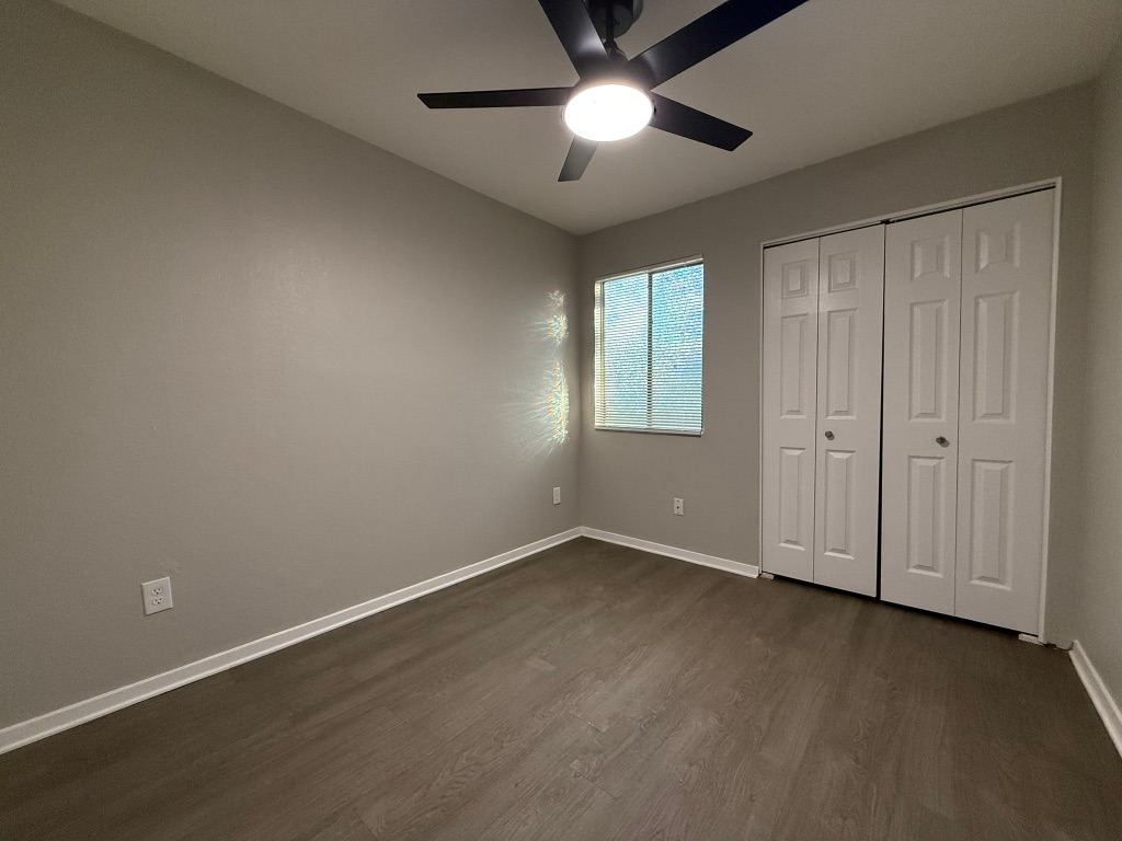 1606 Waterloo Trail, Unit A Austin, TX 78704 - Photo 16 of 17 an empty room with wooden floor fan and windows