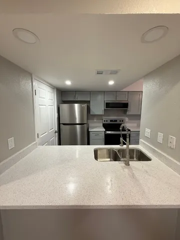 a large kitchen with stainless steel appliances a large counter top