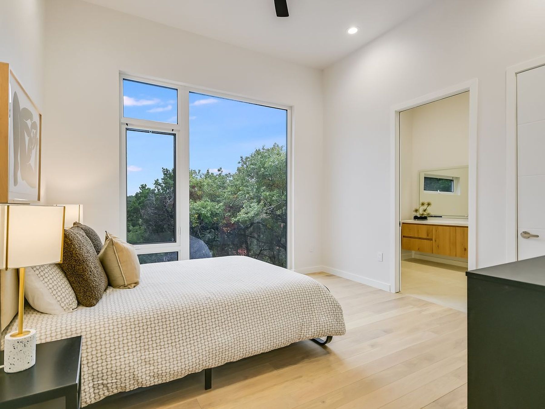 2476 Waymaker Way Austin, TX 78746 - Photo 18 of 31 Floor-to-ceiling windows offer serene outdoor vistas from this inviting sleeping space.