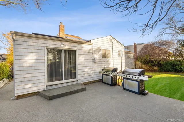 a view of a patio with a table and chairs and a barbeque