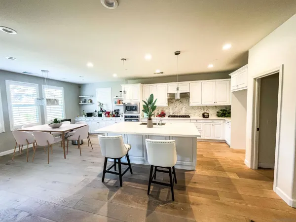 a kitchen with a dining table chairs and view of living room