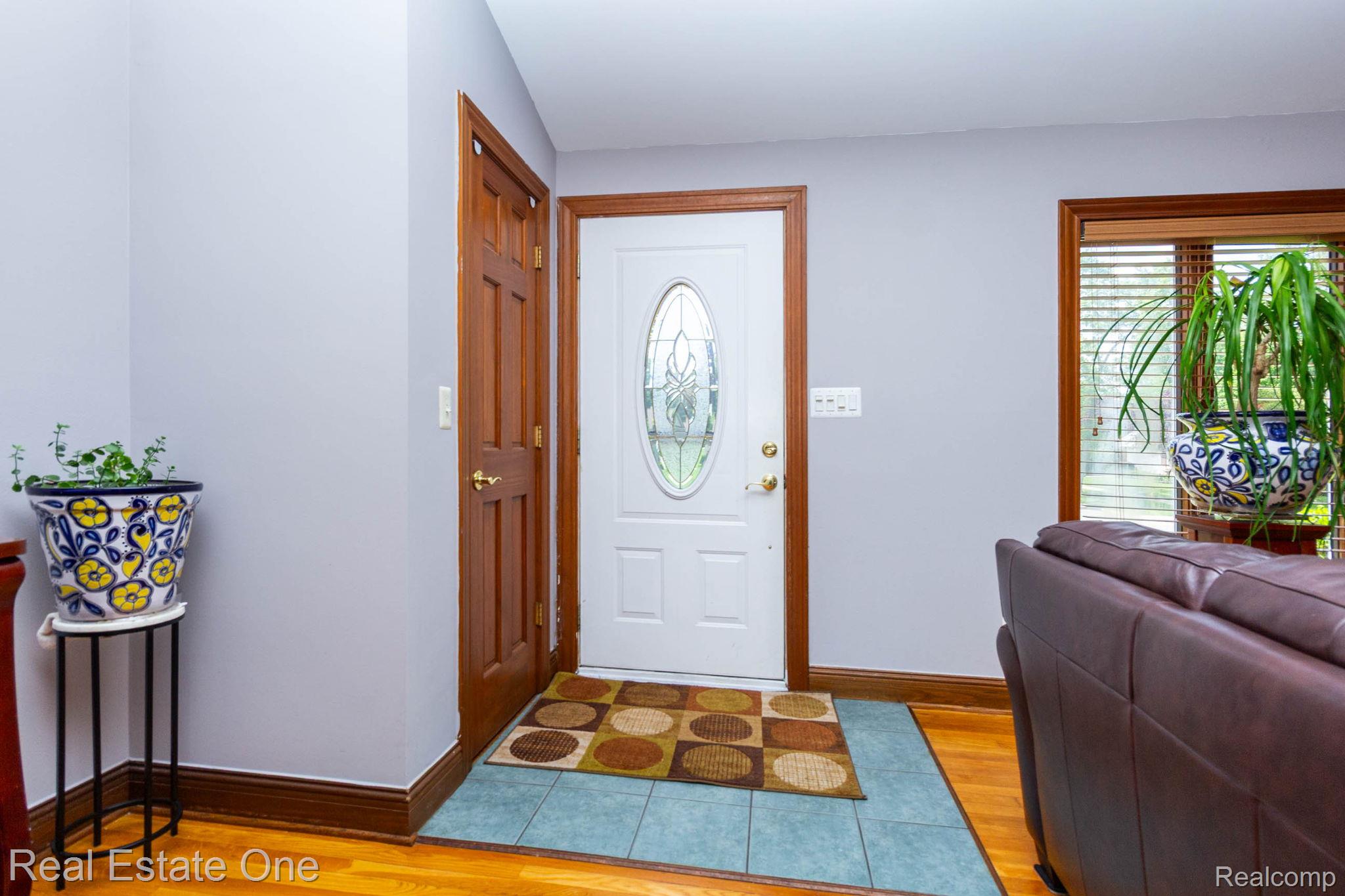 220 Winry Drive Rochester, MI 48307 - Photo 5 of 35 Entryway featuring a white door with an oval decorative glass insert, wood trim, and a tile floor