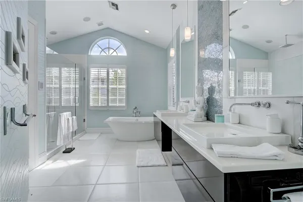 a spacious bathroom with a bathtub shower sink and mirror